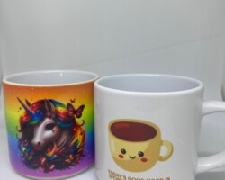Twee bedrukte mokken, een met regenboogeenhoorn en een met lachend kopje