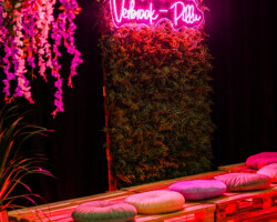 Feestzaal met neonbord en loungehoek van pallets op een bruiloft