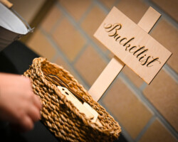 Houten bordje met opschrift Bucketlist in een rieten mandje